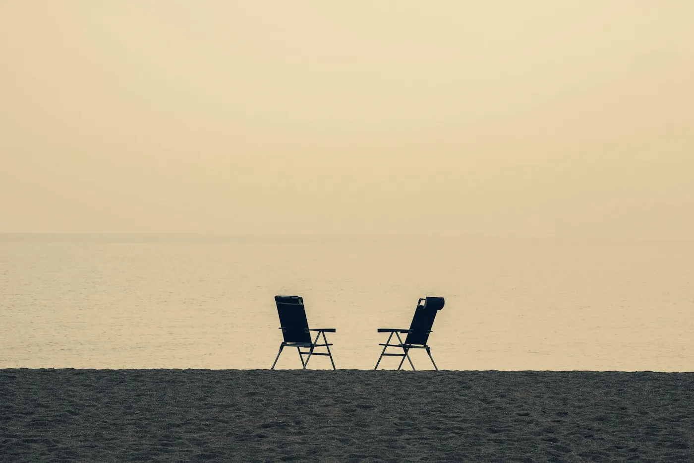 Deux chaises longues face à la mer dans la lumière du soir